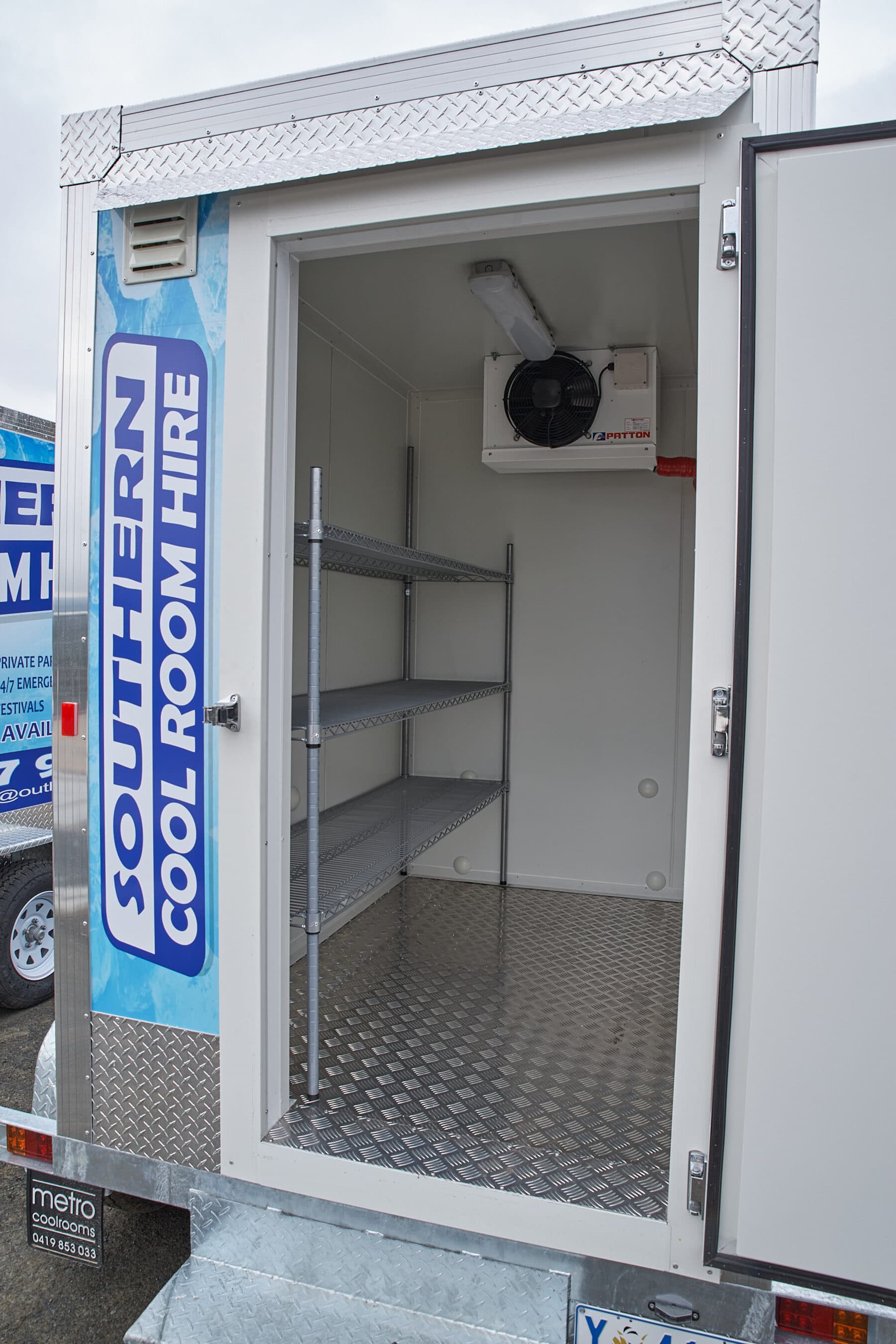 Rear door open on a cool room trailer with shelving visible inside